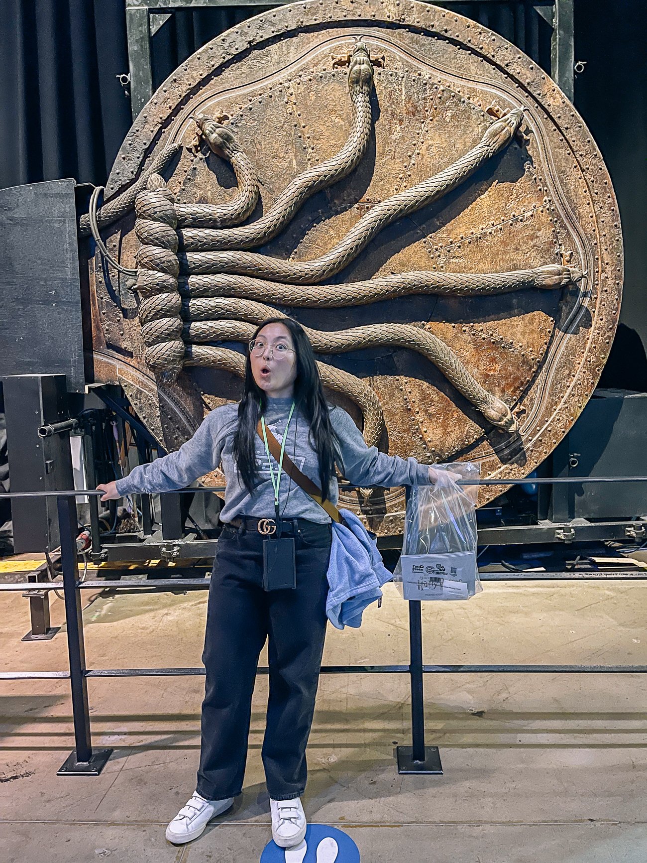 Kaitlin looking surprised in front of the door to the Chamber of Secrets with 6 snakes