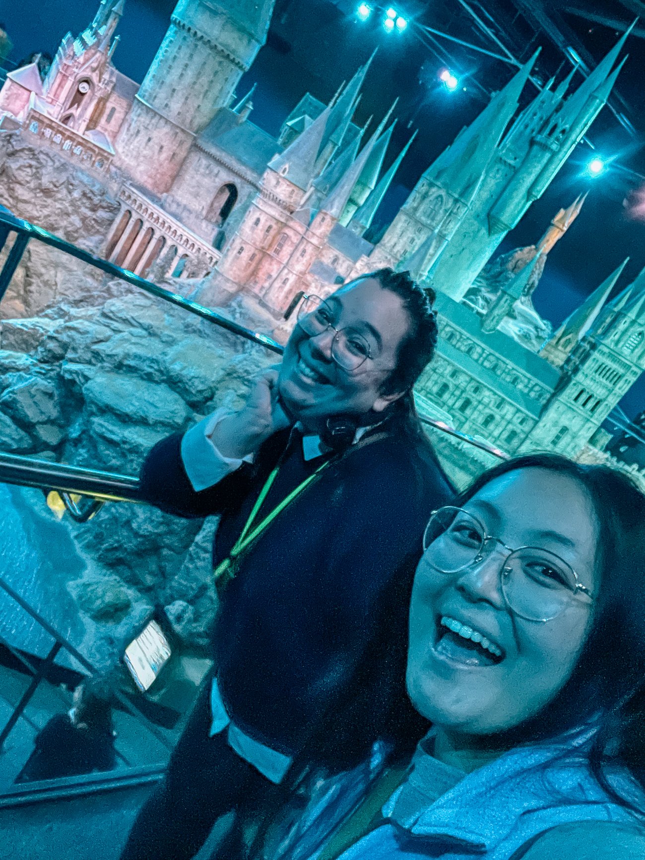 Kim and Kaitlin in front of Hogwarts castle diorama in blue evening light