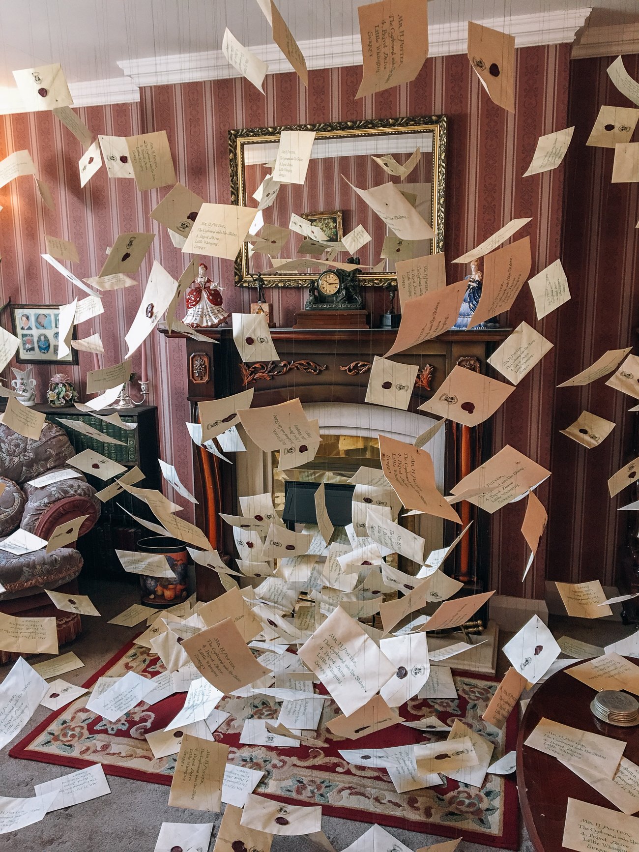 Hogwarts letters suspended by wires flying out of the fireplace at number 4 Privet Drive