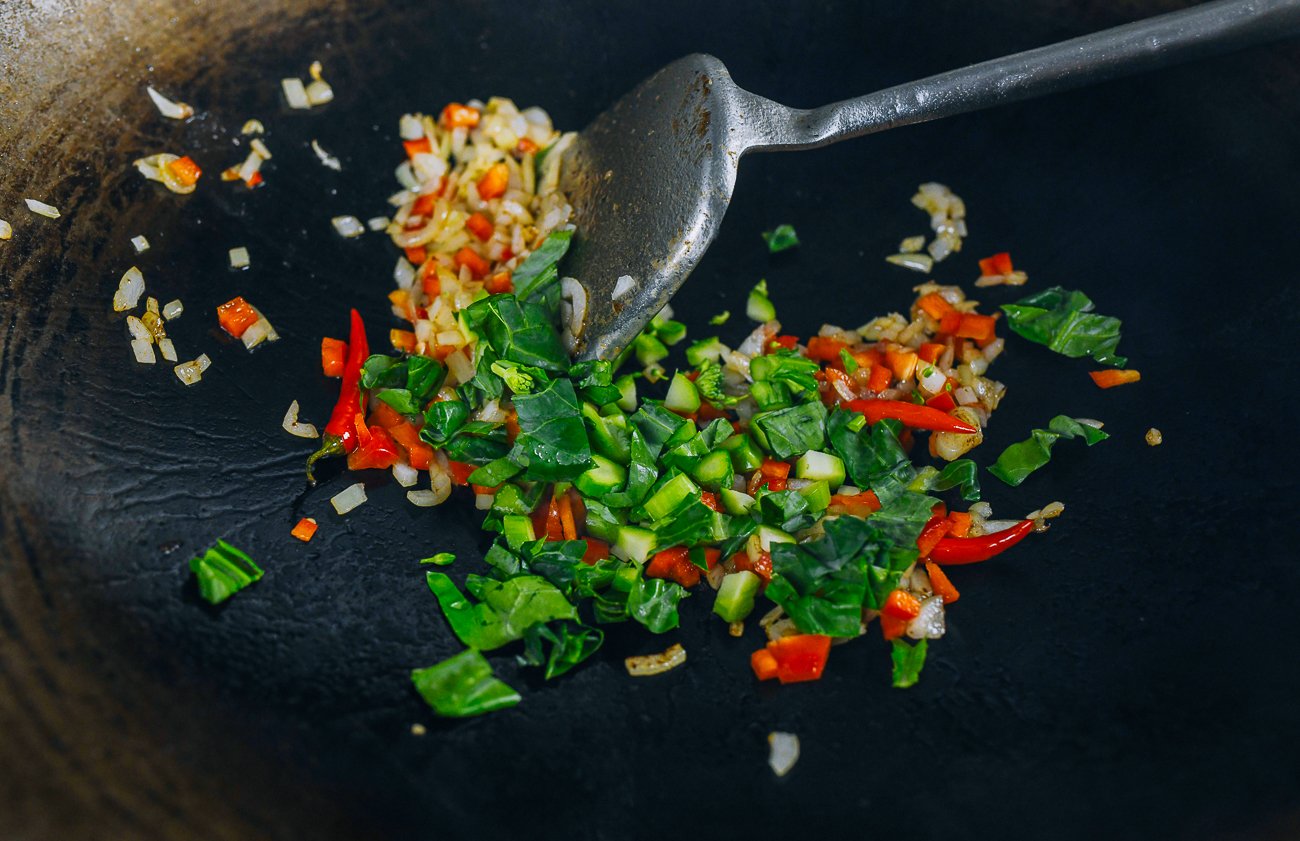 Chinese broccoli, red bell pepper, and onion in wok