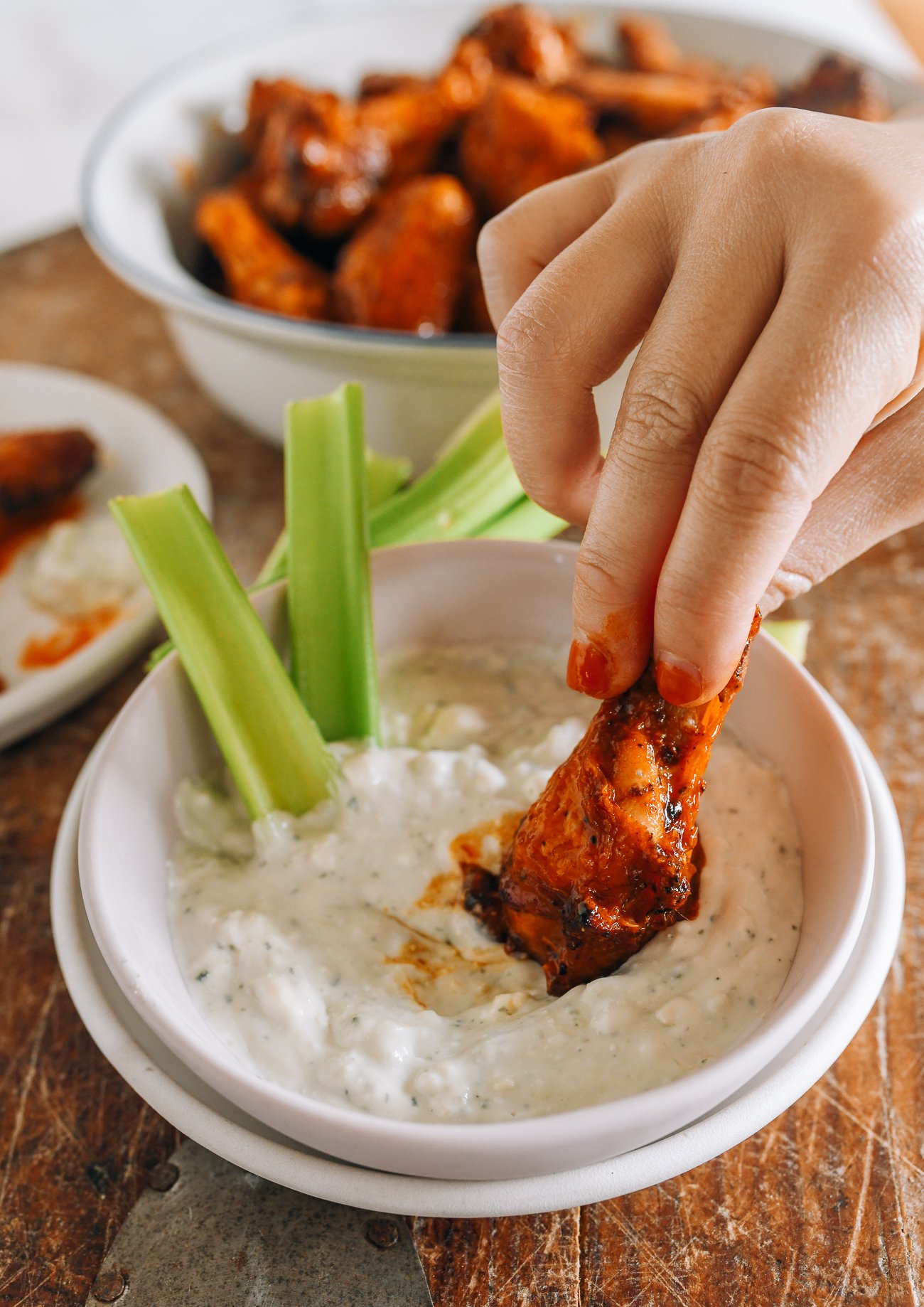 dipping hot wing into blue cheese dressing