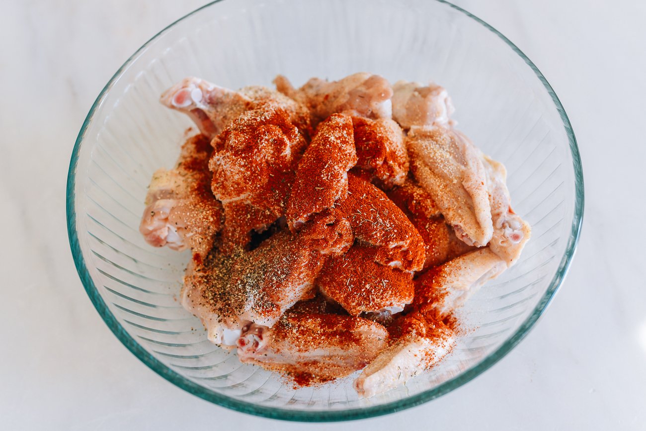 smoked paprika, garlic powder, onion powder, thyme, and pepper on raw chicken wings