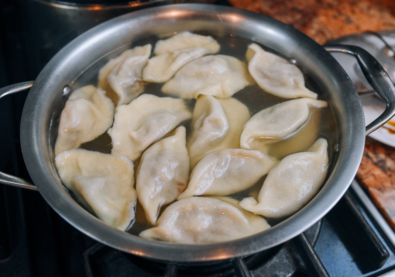 dumplings cooking in pot of boiling water