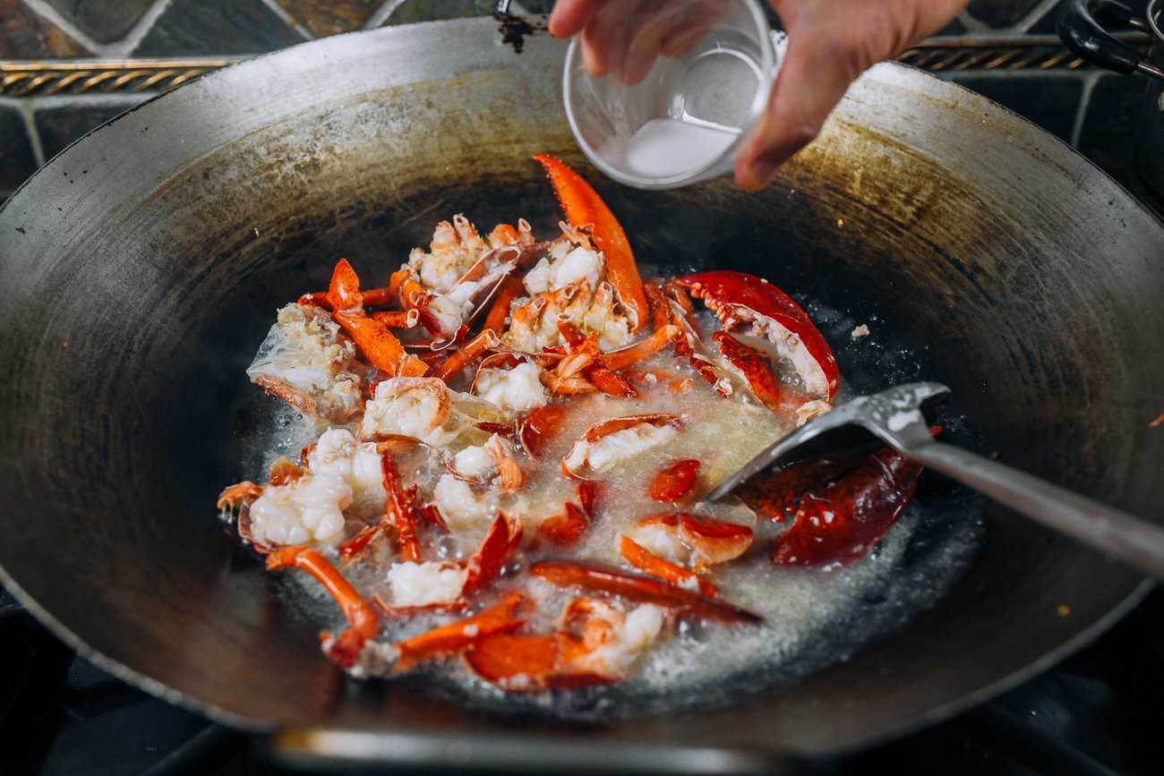 adding cornstarch slurry to lobster in wok