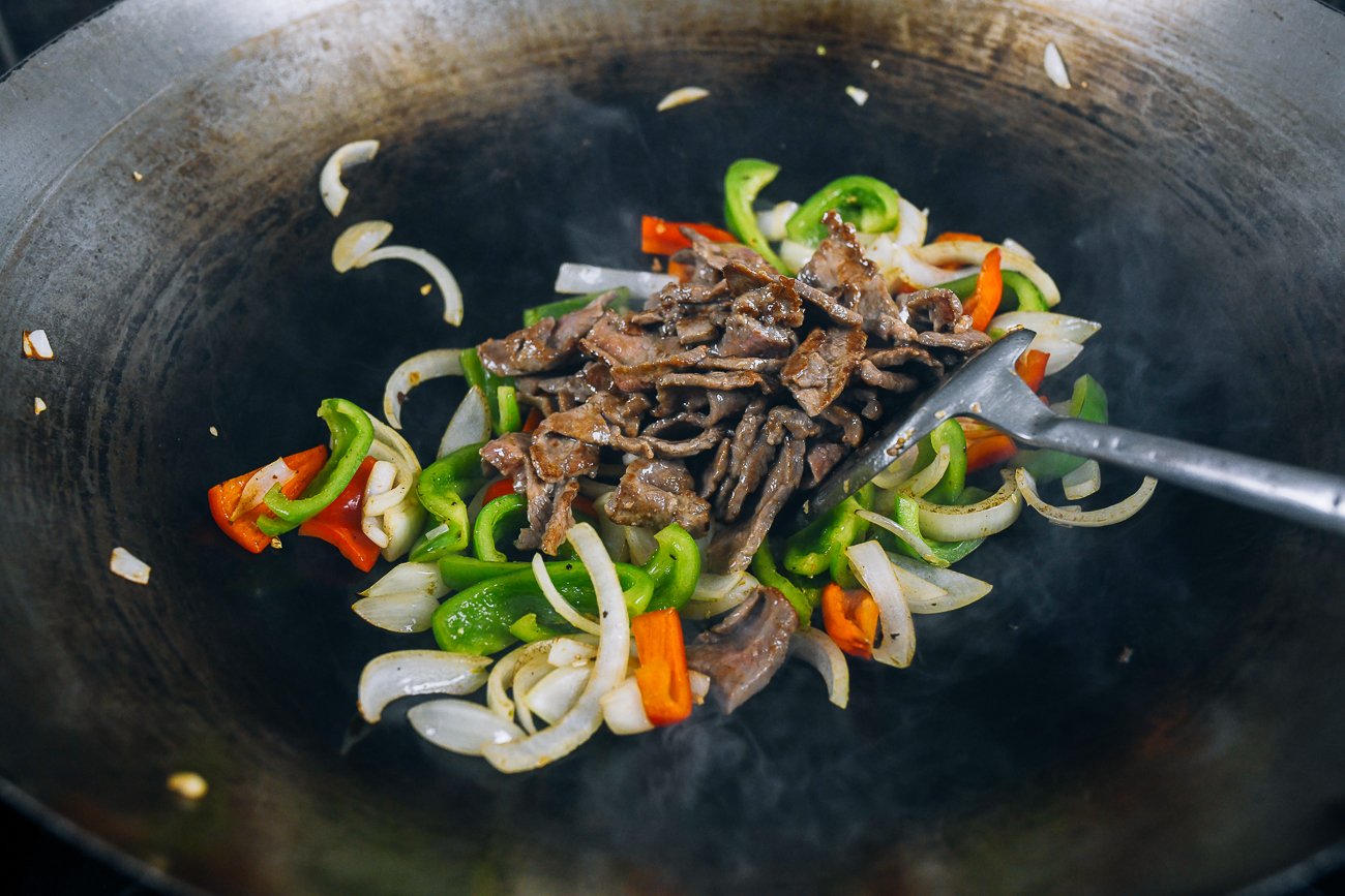 beef, bell peppers, and onions in wok