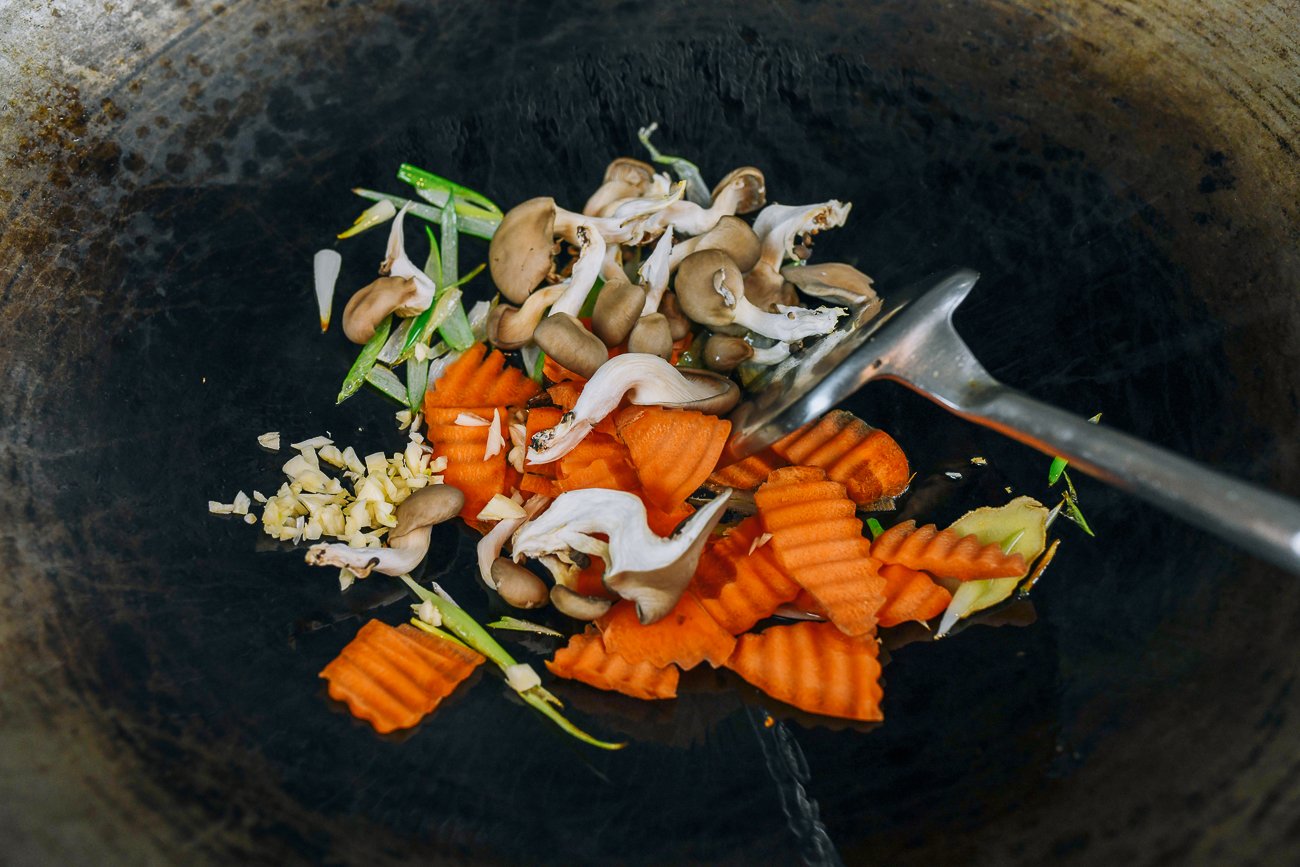 mushrooms, carrots, and scallions in wok