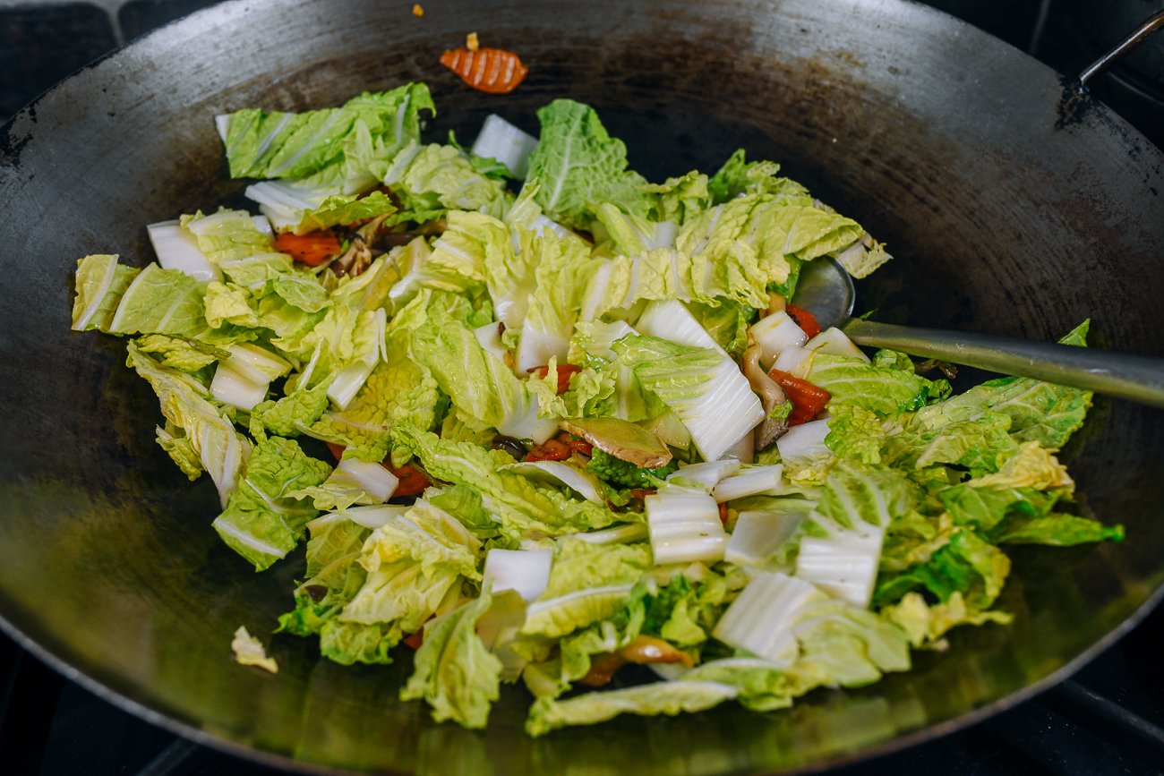 adding napa cabbage to wok