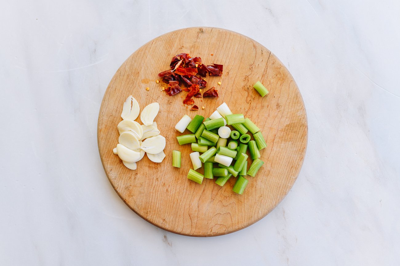 garlic, scallion, and chilies on cutting board