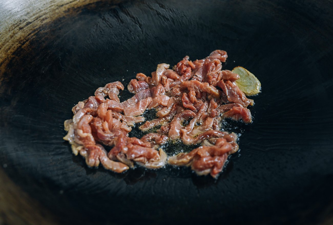 searing pork in wok