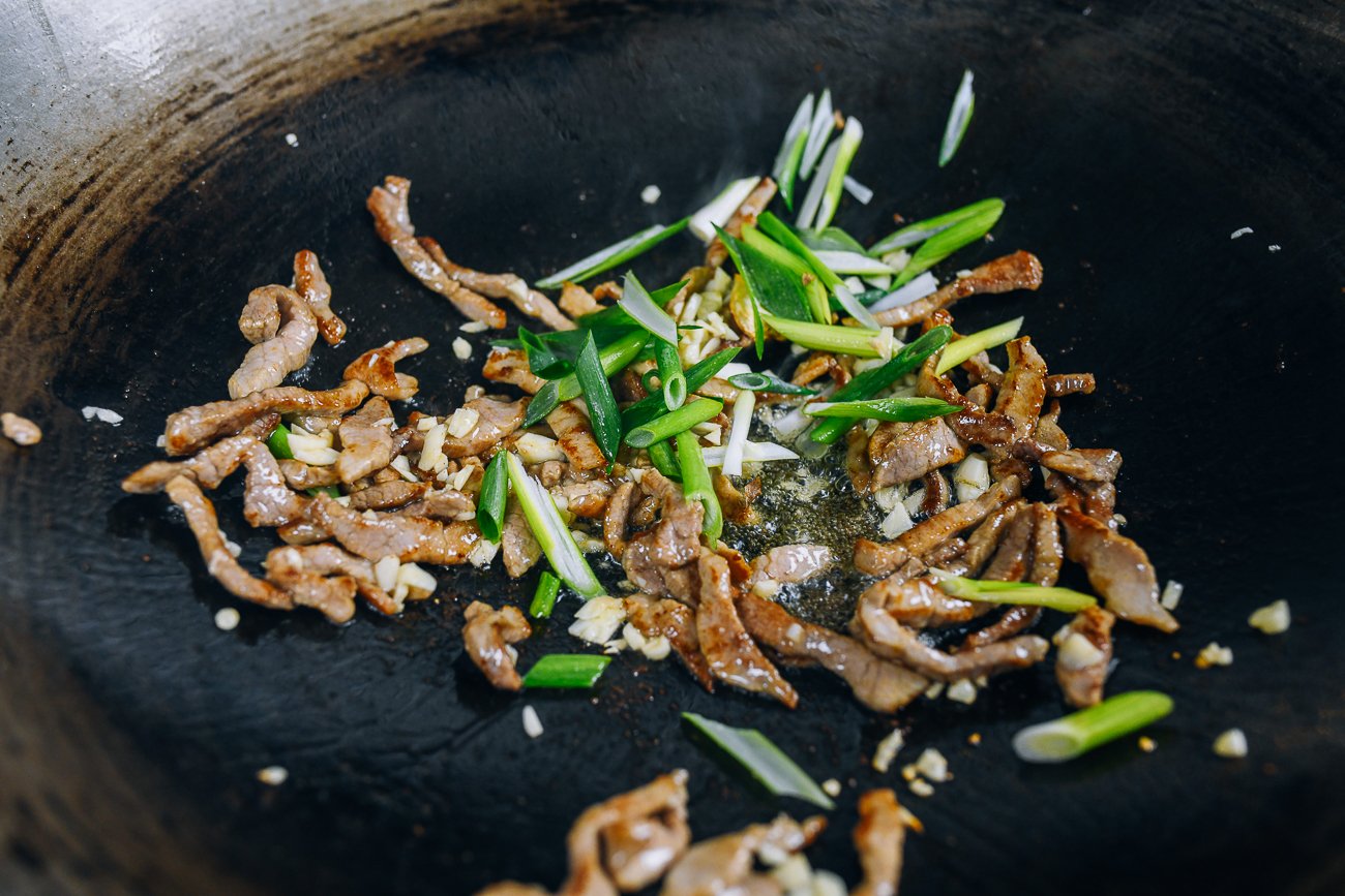 pork and scallions in wok