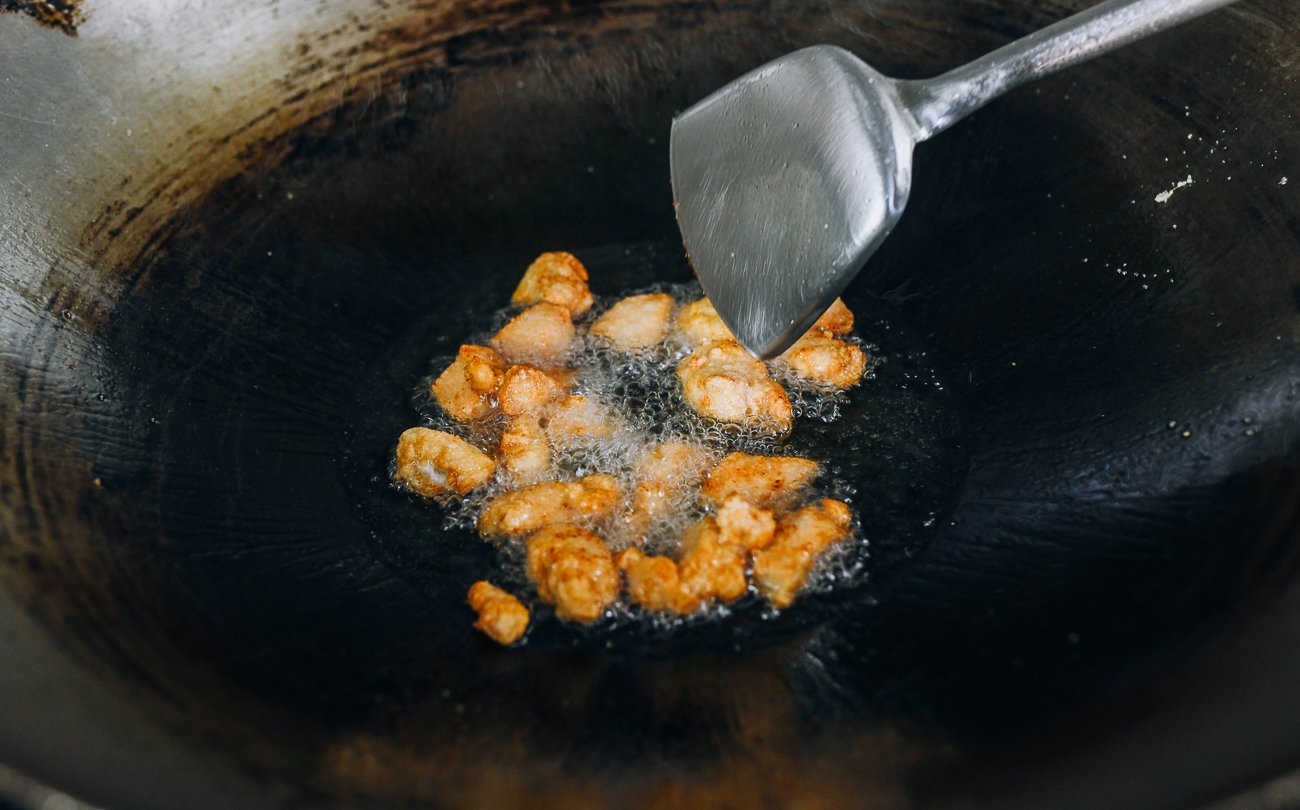 shallow-frying boneless chicken pieces in wok
