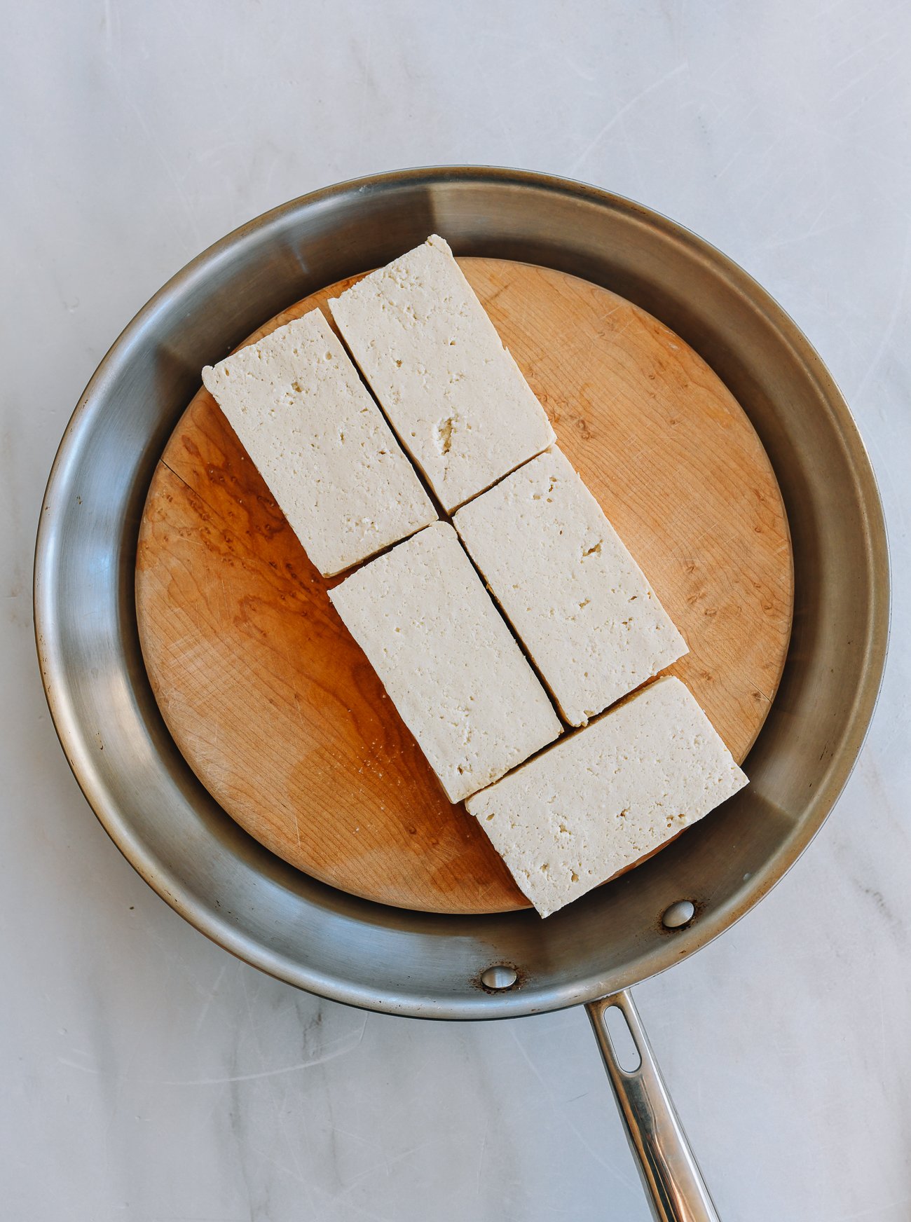 slices of tofu on cutting board in pan