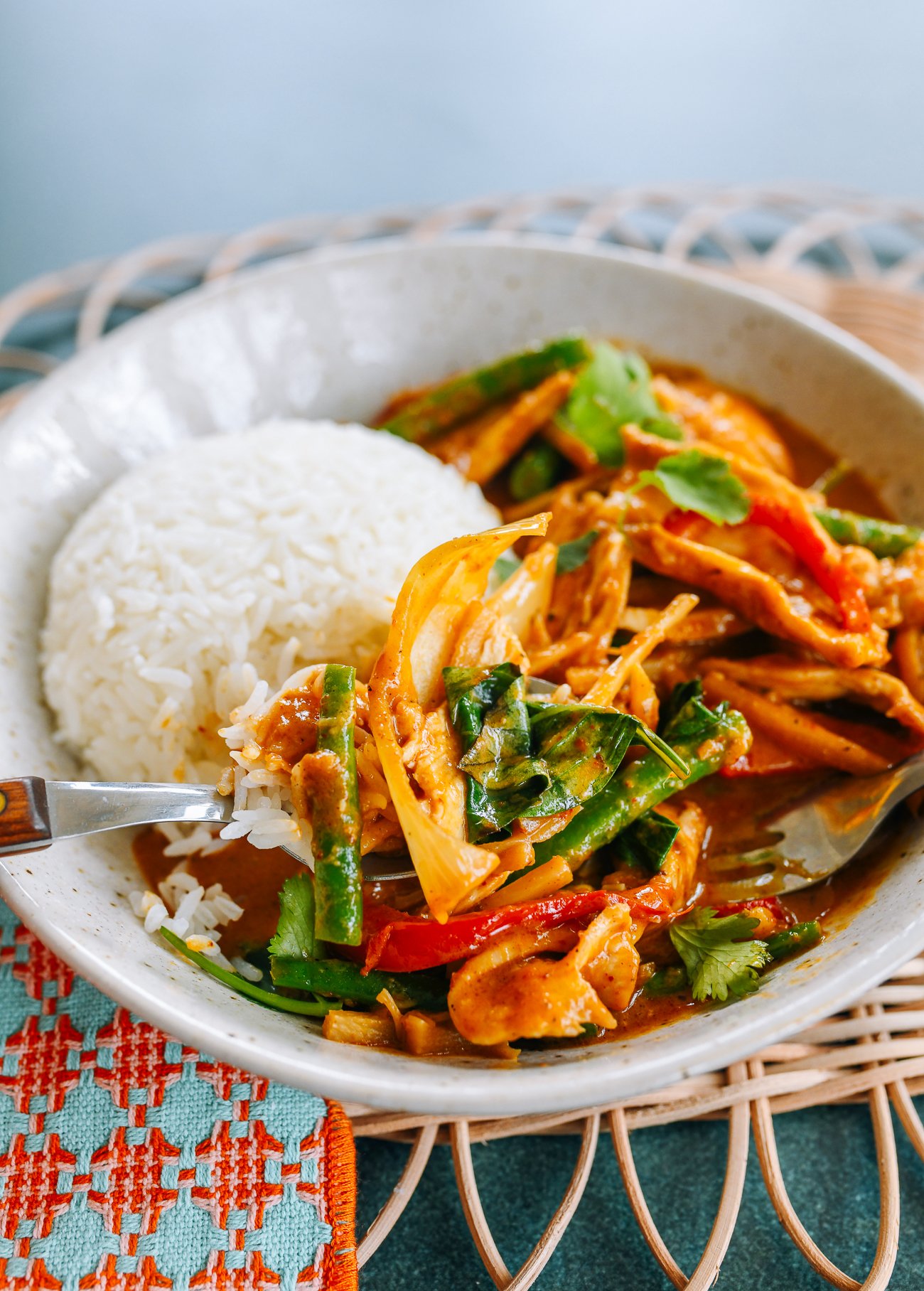Fork digging into Thai Red Curry Chicken with Vegetables and Thai Basil