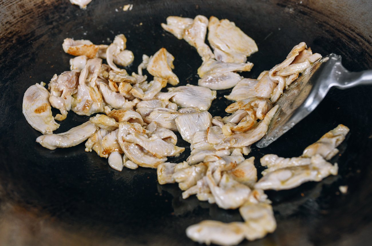Searing sliced chicken breast in wok