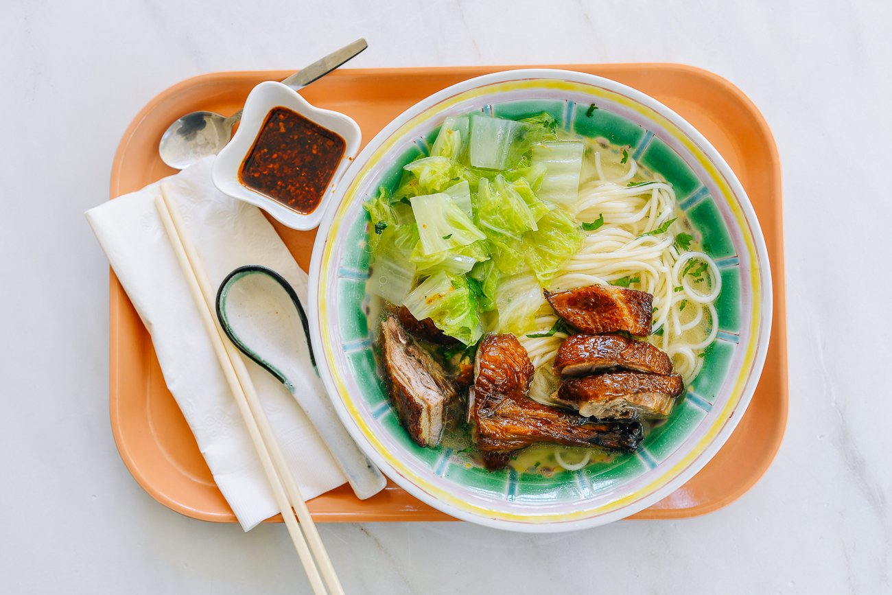 duck noodle soup with chopsticks and Chinese soup spoon, chili oil on the side