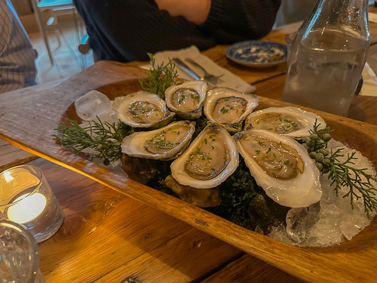 Chilled oysters with chives and garlic on a bed of juniper at The Lost Kitchen