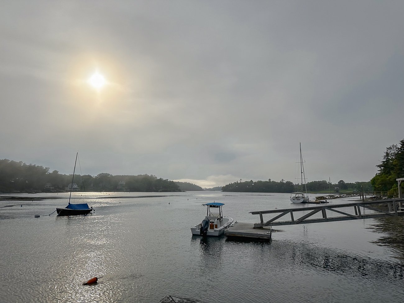 A view of an ocean inlet in Southport, Maine with private docks and small docked boats and buoys