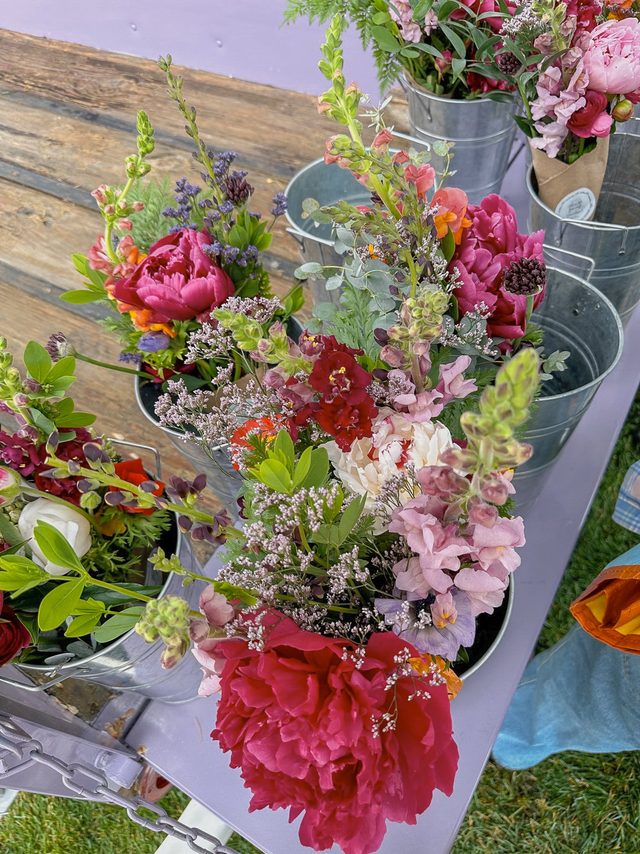 Bouquets of Peonies and snapdragons in metal buckets at the Boothbay Harbor farmer's market