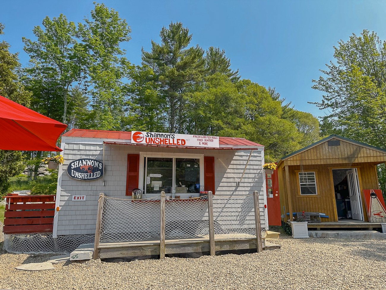 Shannon's Unshelled in Boothbay Harbor, a small white seafood shack with a red roof