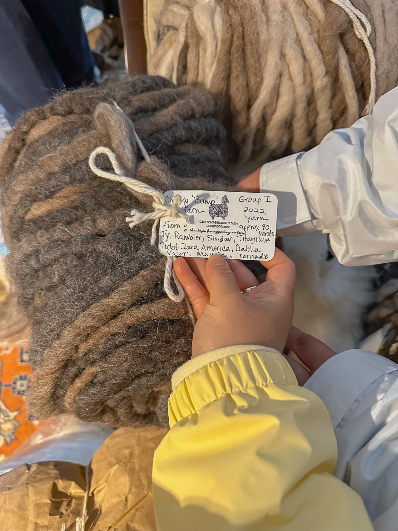 Ball of thick yarn labeled with names of alpacas who the wool came from