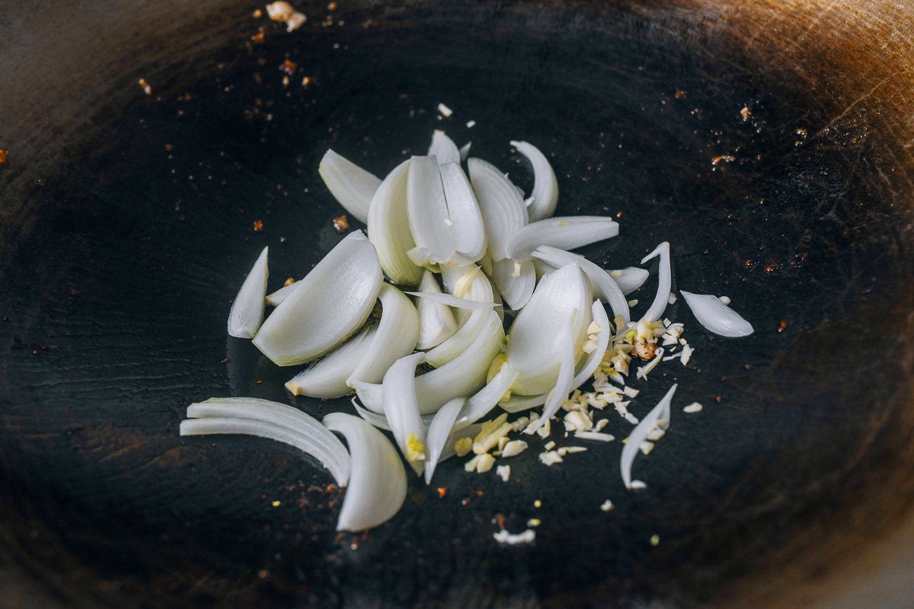 adding onions to wok