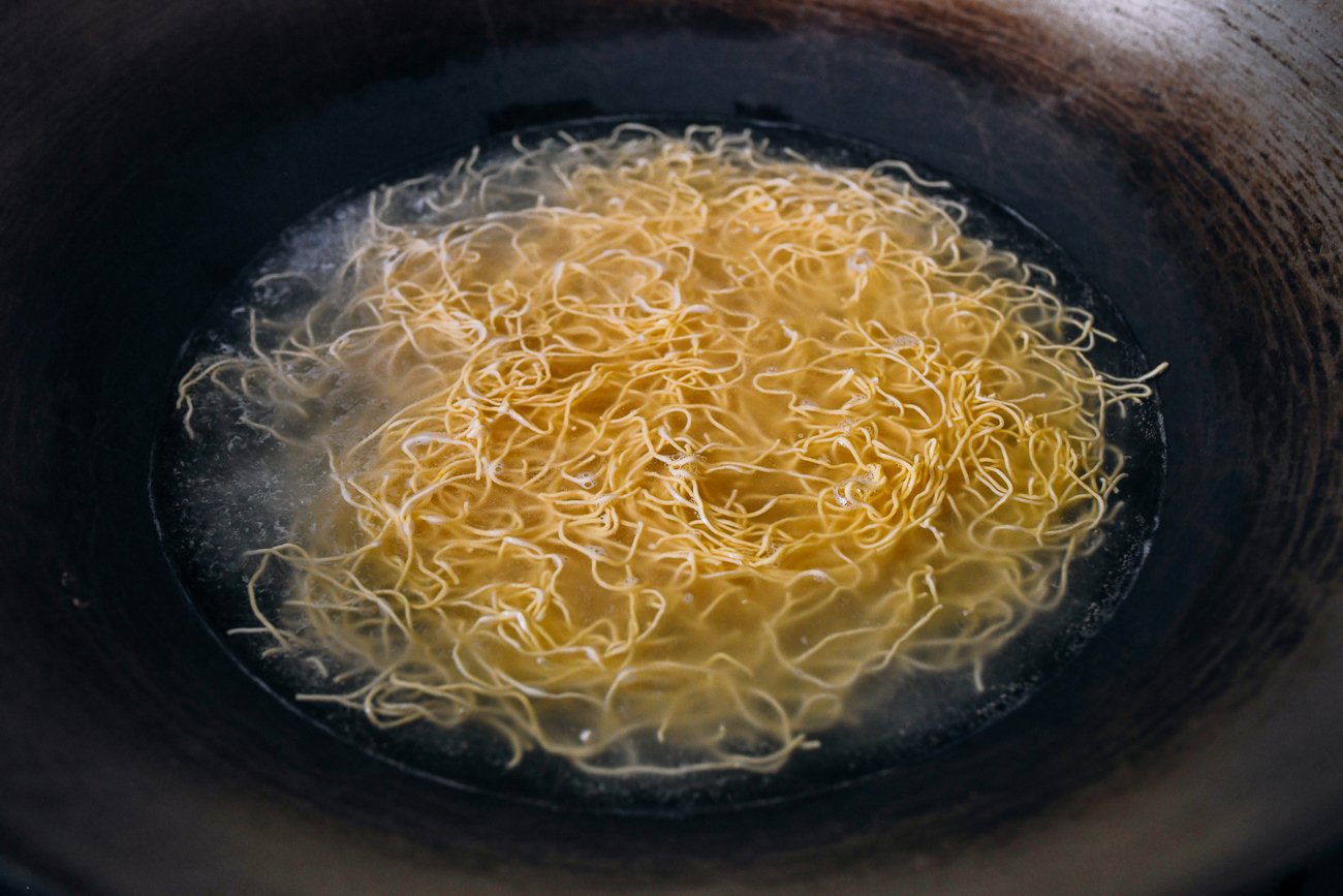 boiling hong-kong-style pan-fried noodles in wok