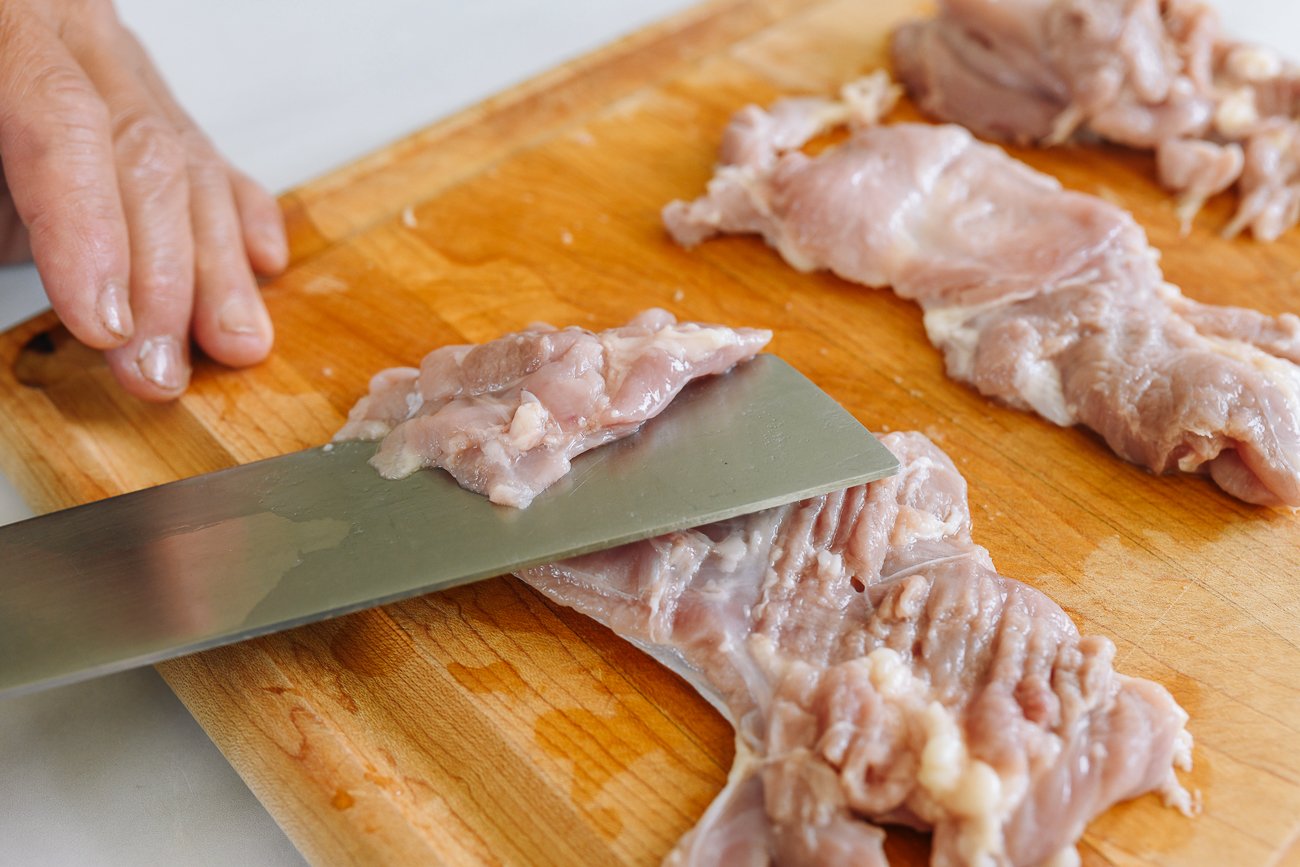 slicing boneless skinless chicken thighs into thin pieces