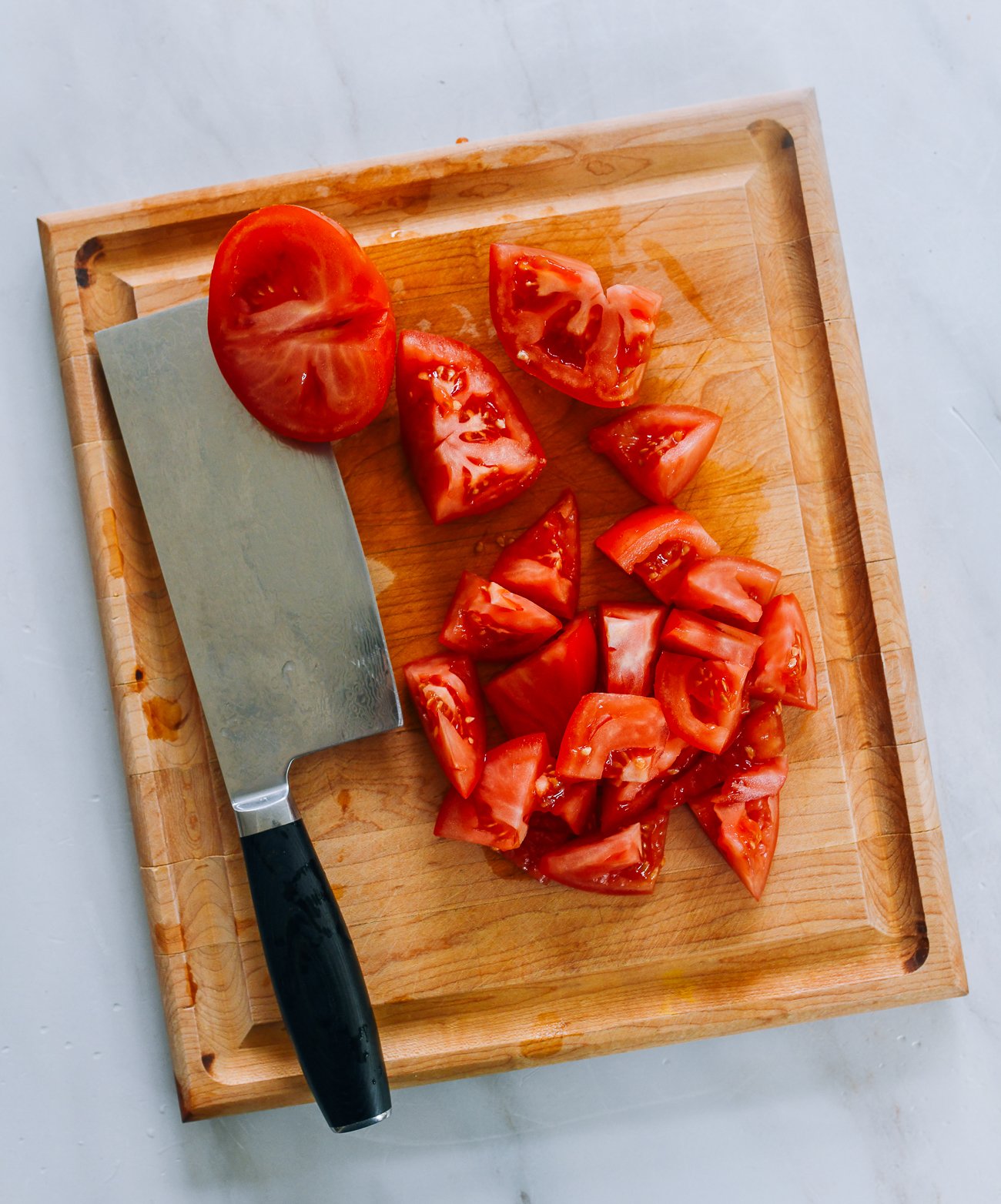 Cutting tomatoes into chunks with Chinese cleaver