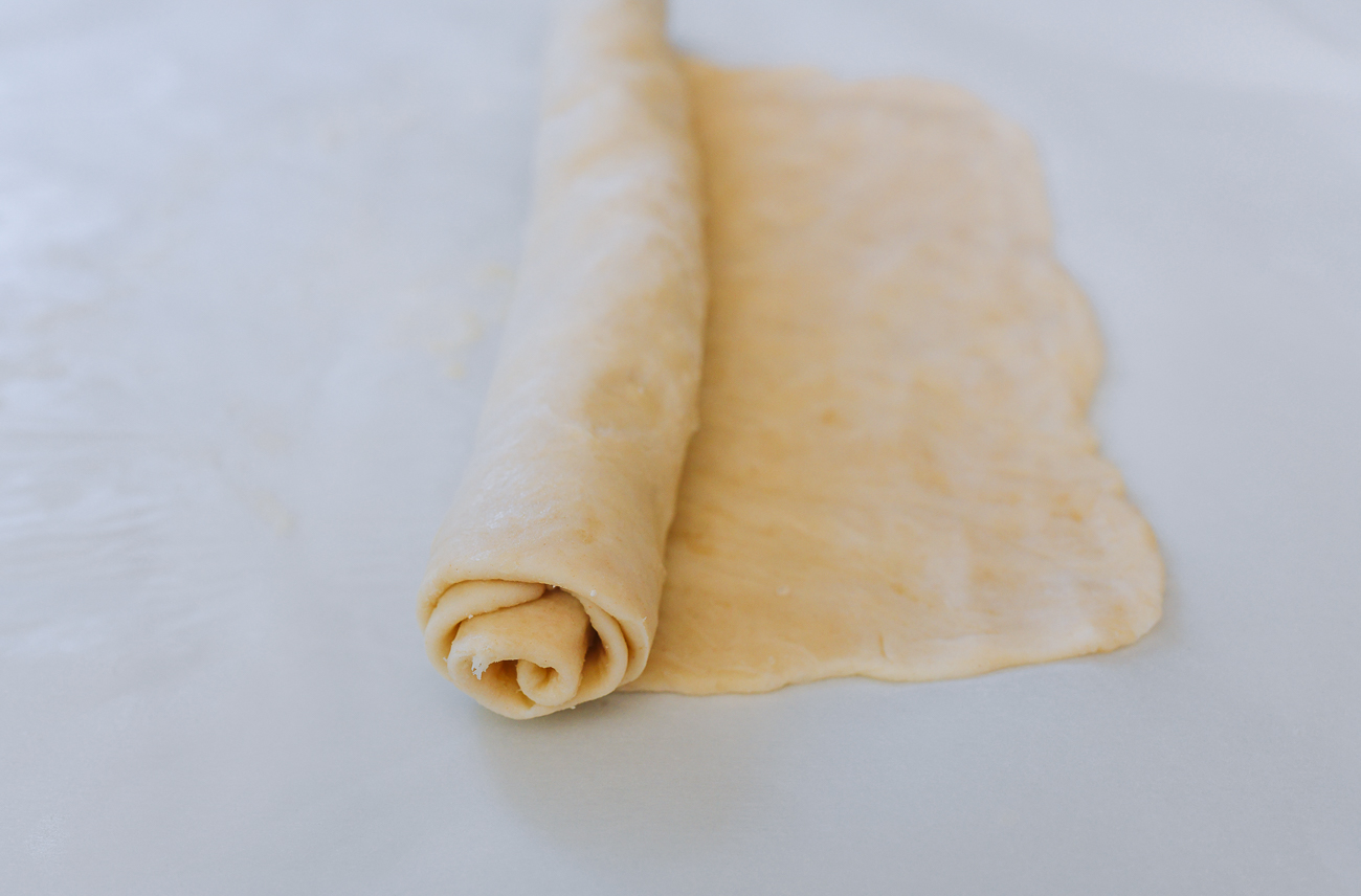 rolling short side of dough rectangle into a roll