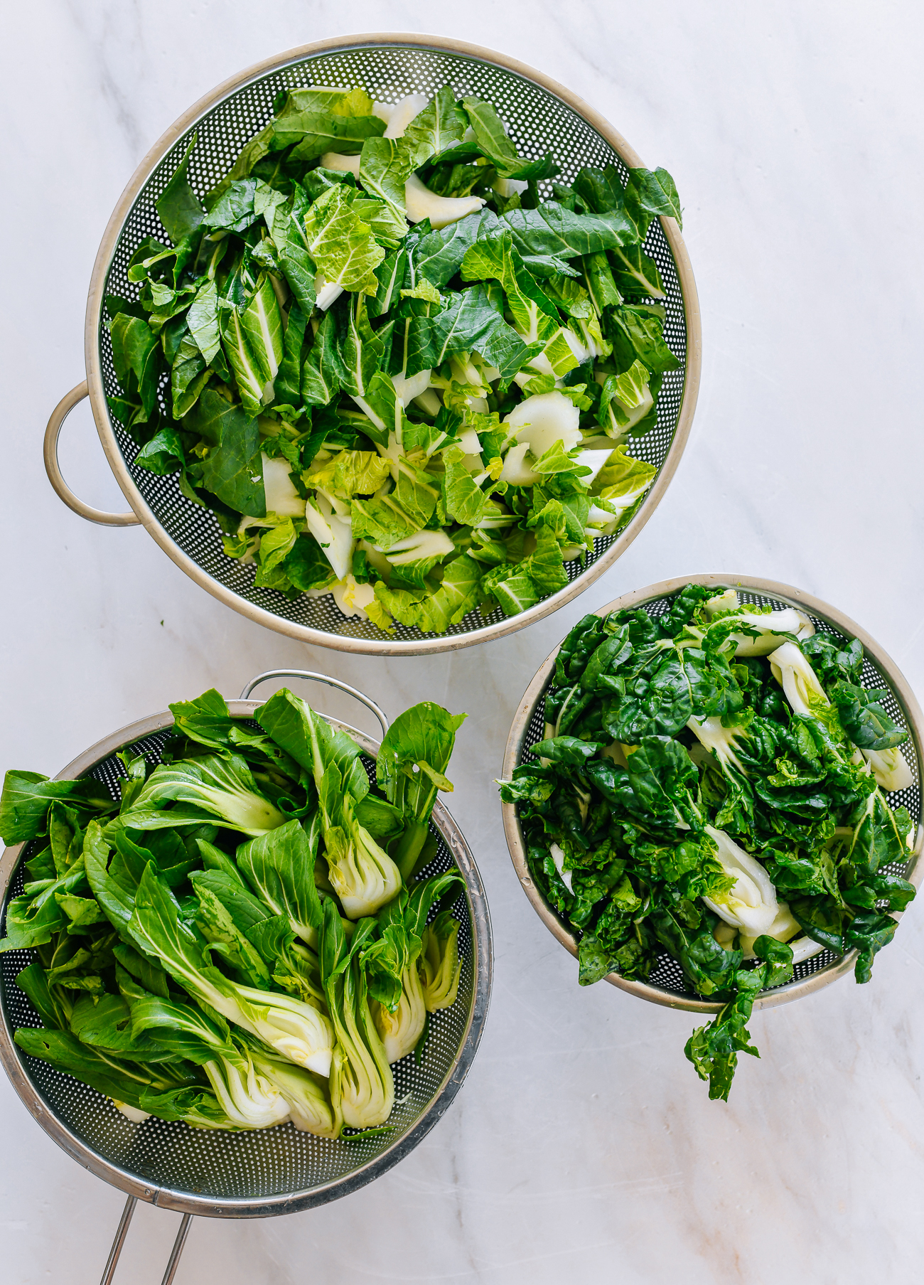 washed bok choy in colanders