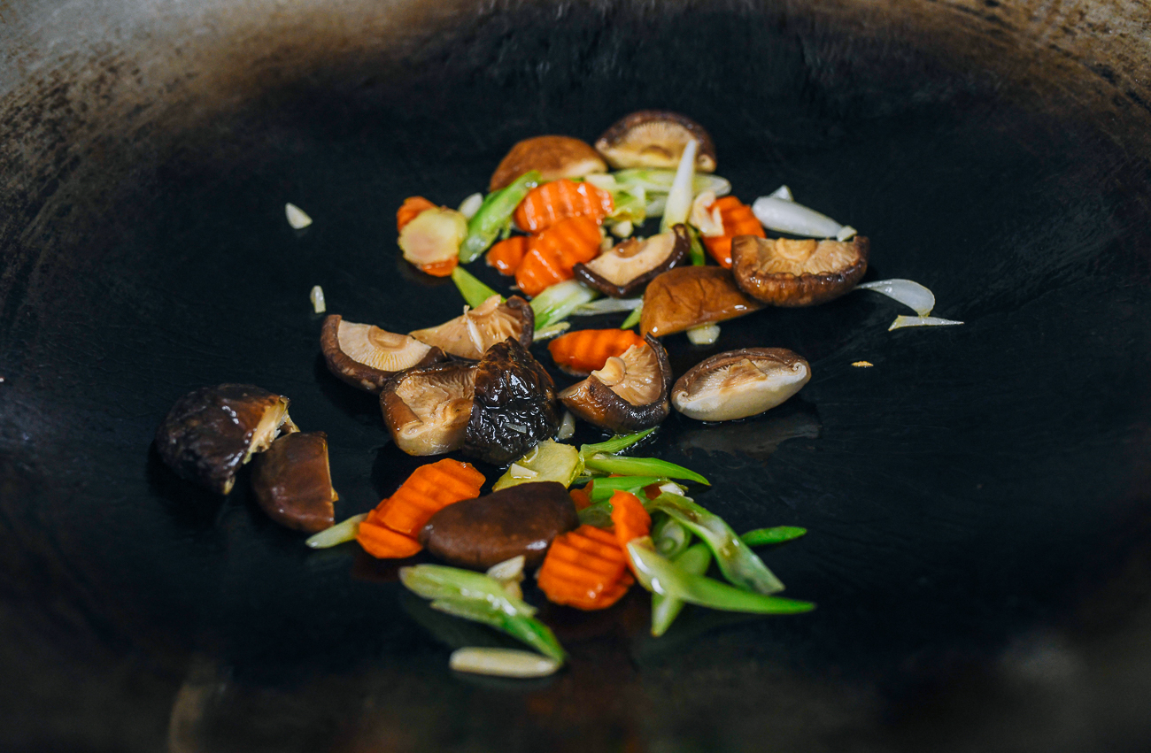 reconstituted shiitake mushrooms, carrots, scallions, garlic and ginger in wok