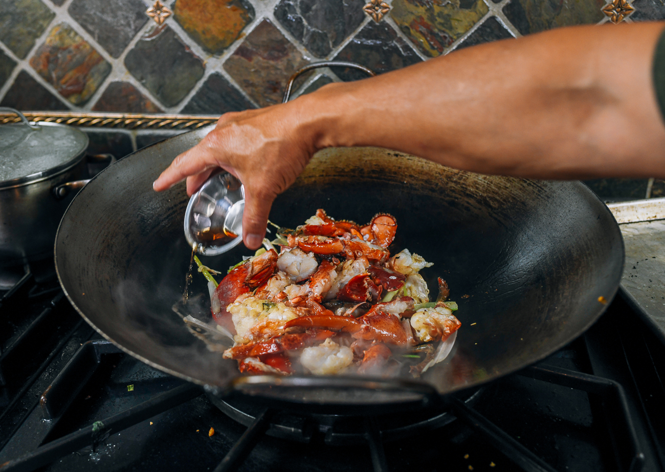 pouring Shaoxing wine into wok with lobster