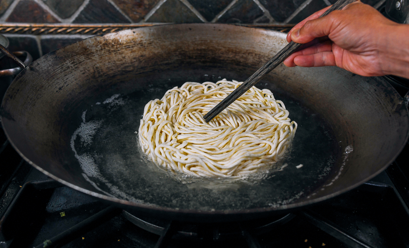 adding e-fu noodle cake to boiling water
