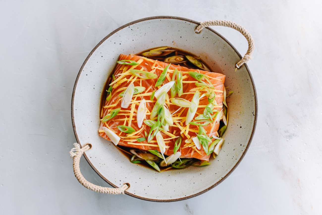 ginger, scallion, and soy sauce seasoned salmon fillet in dish