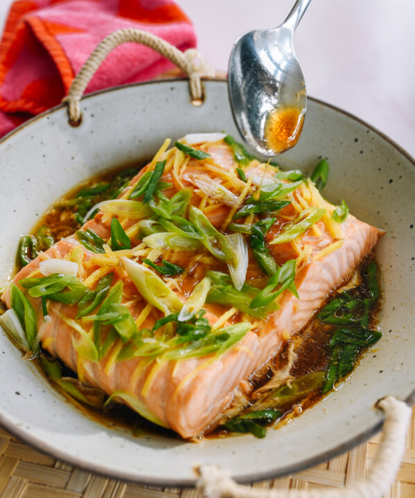pouring sauce over steamed salmon fillet