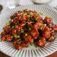 plate of firecracker chicken garnished with scallions