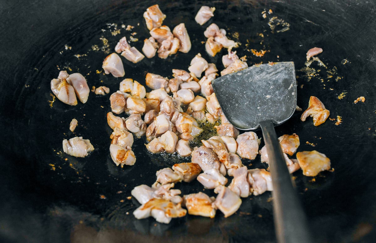 searing chicken pieces in wok