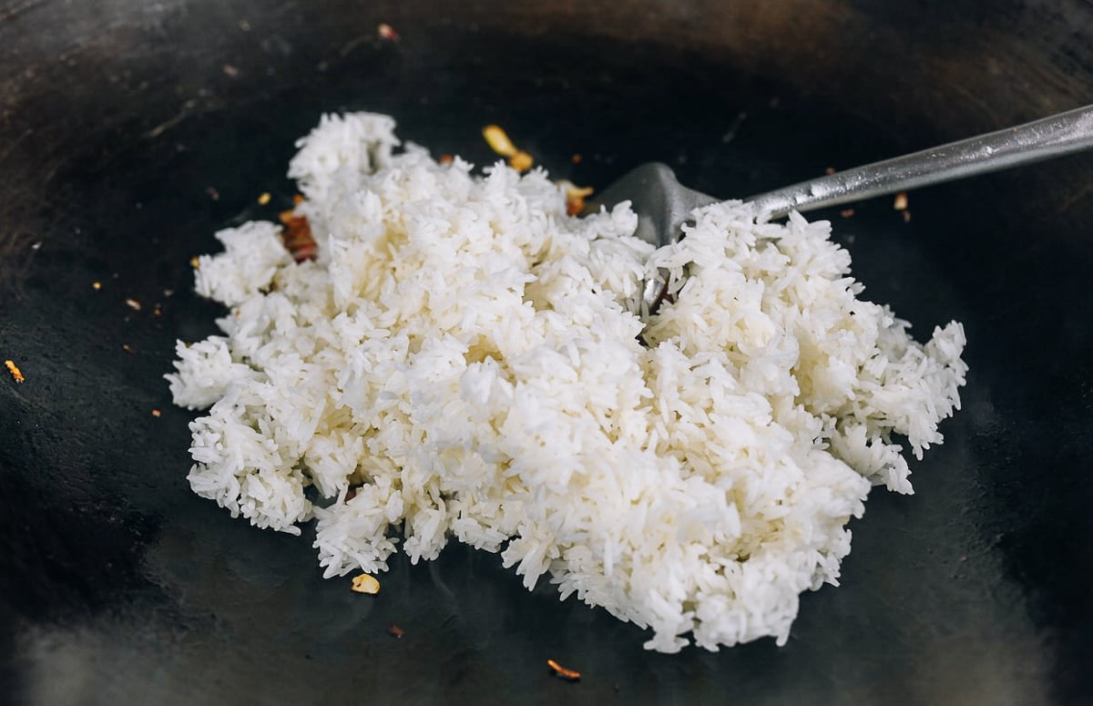 adding cooked rice to wok