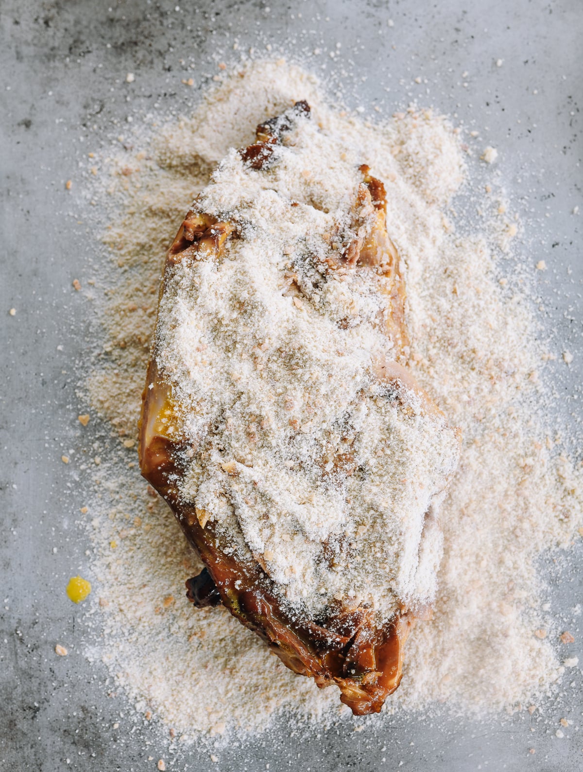 pressing breadcrumbs into egg coated de-boned duck