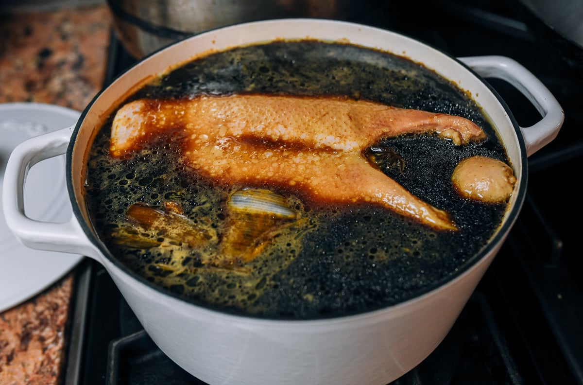 whole duck in pot with braising liquid