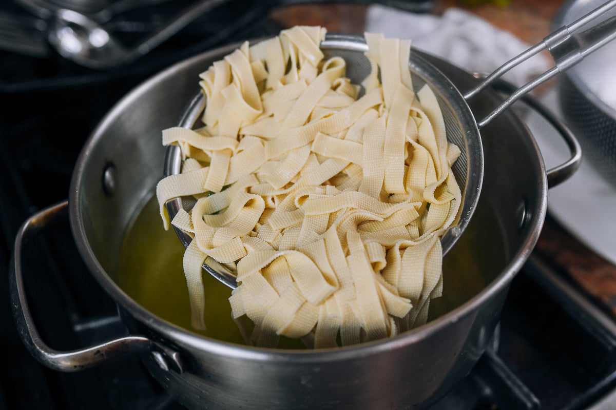 removing blanched tofu skin from water using a strainer