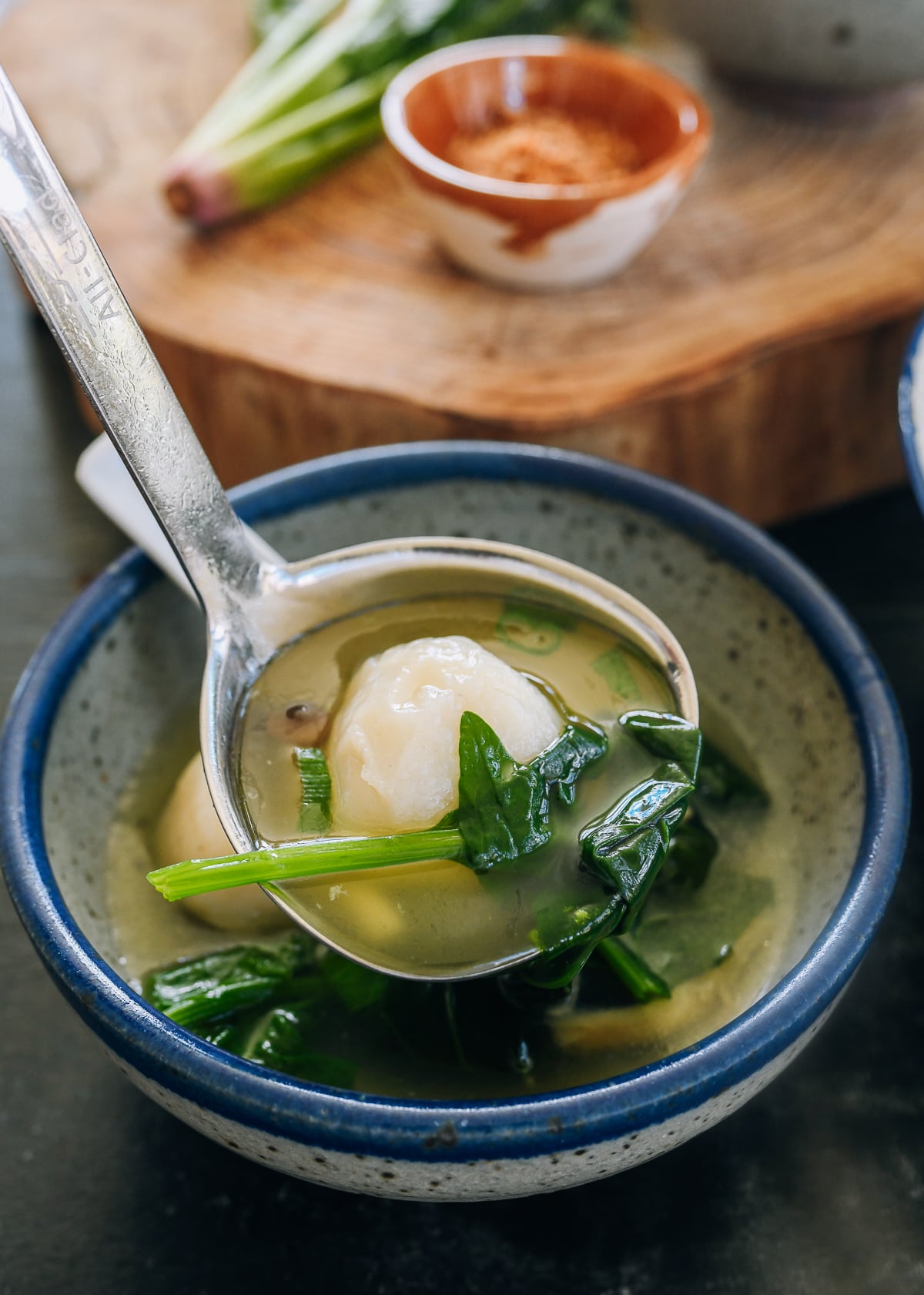 scooping fish ball soup into a bowl