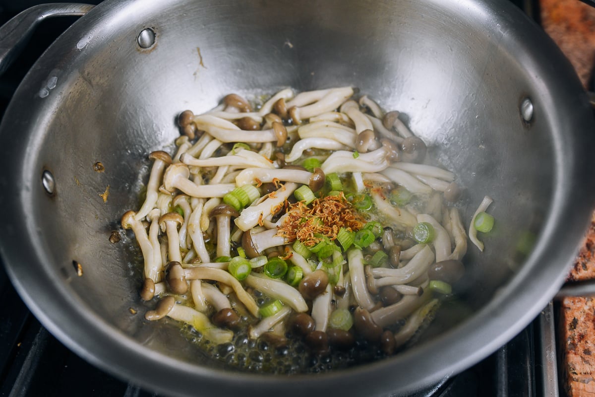 cooking mushrooms, white parts of scallion, and dried shrimp in pot