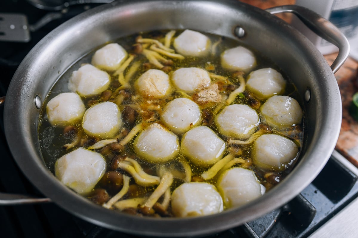 fish balls simmering in soup with mushrooms