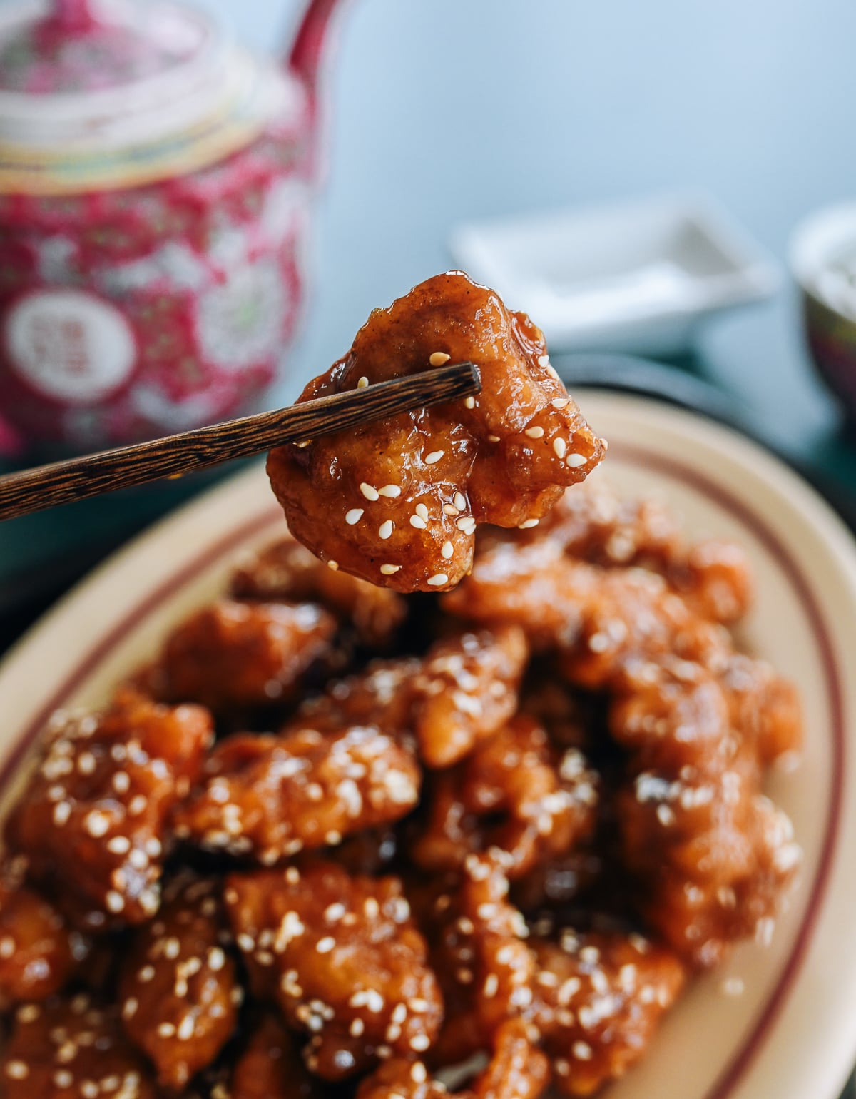 chopsticks picking up a piece of sesame chicken