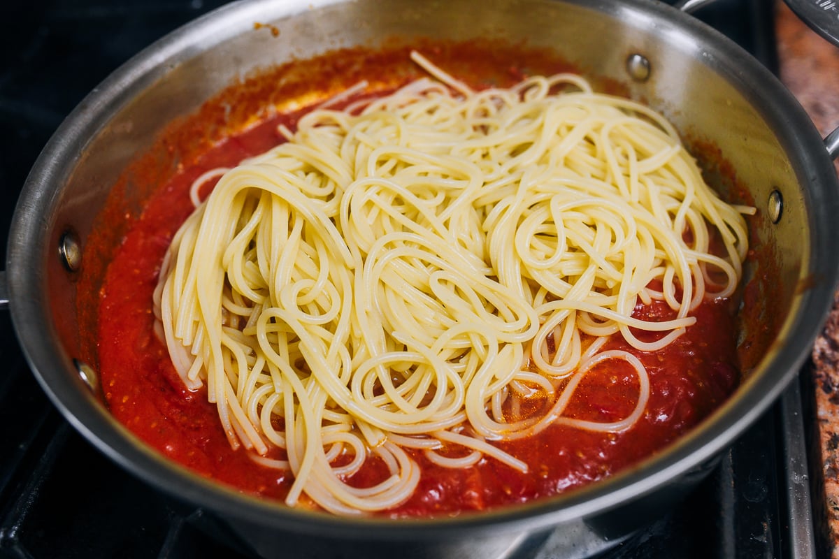 spaghetti added to tomato sauce