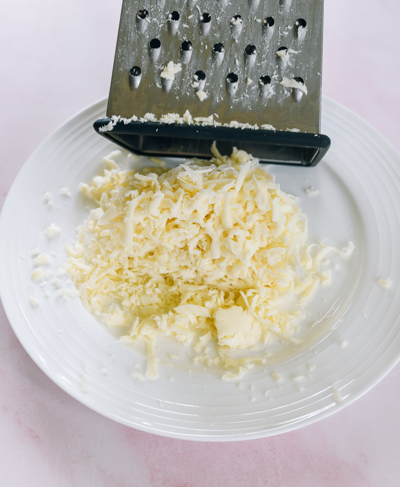 grating mozzarella cheese on box grater