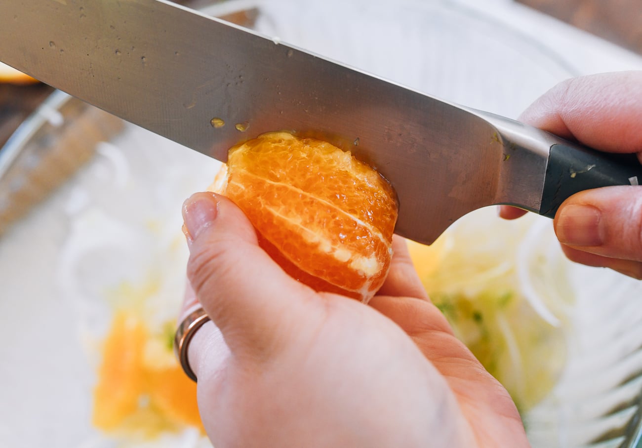 slicing into orange wedges