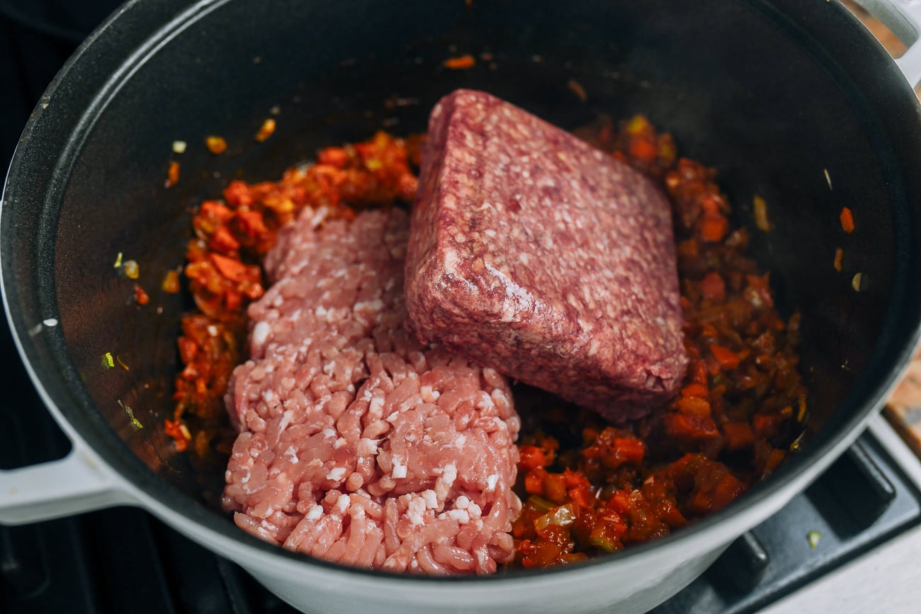 ground beef and pork added to vegetables and tomato paste