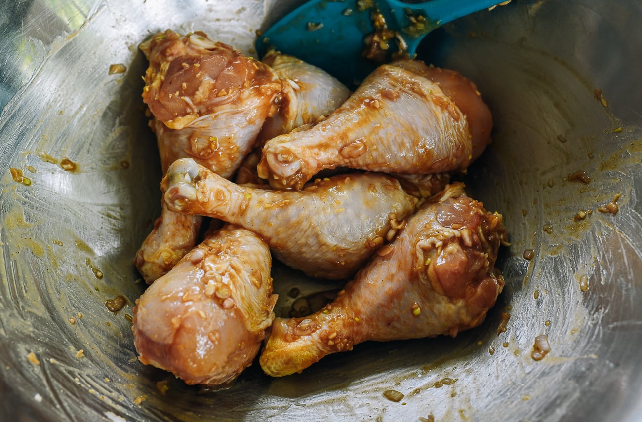 marinated chicken legs in stainless steel bowl